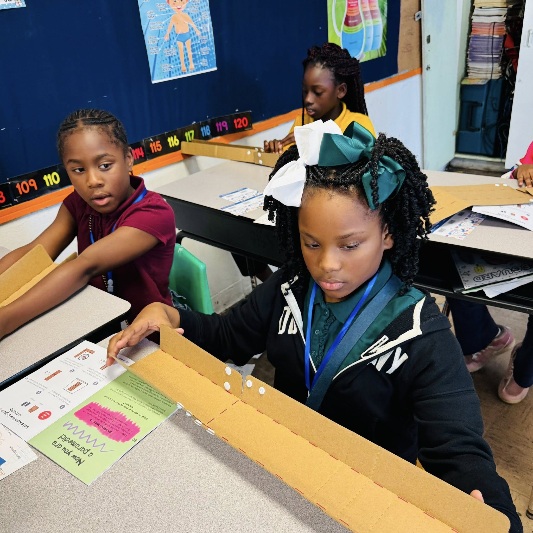 A girl looking at a long strip of cardboard.
